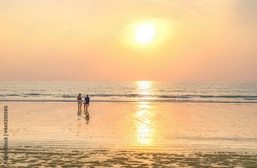 Family walking towards the sea on a Khao Lak beach.