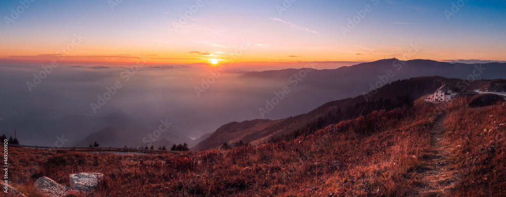 Scenic view of the Vittorio Veneto hut on the top of mount Pizzoc (Treviso province, veneto, italy) against clouds  at sunset in autumn
