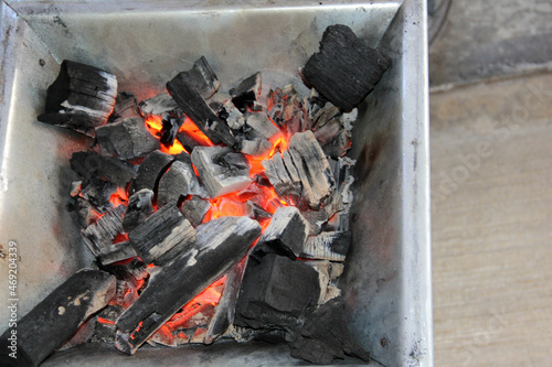 Chunks of charcoal lighting a fire in a cooktop for cooking or roasting meat in the open air 