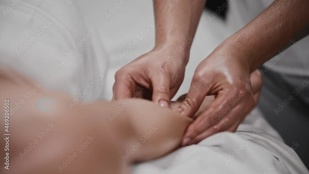 Young woman receiving a massage - point massaging her hand with an oil Young woman receiving a massage - point massaging her hand with an oil
