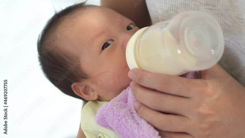Close up newborn baby drink milk from bottle. Babyhood, family, concept Close up newborn baby drink milk from bottle. Babyhood, family, concept