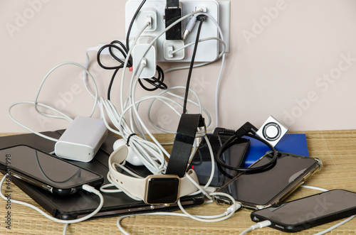 Sharing power: power adapter and power banks charging multiple devices in a messy cable connection photo