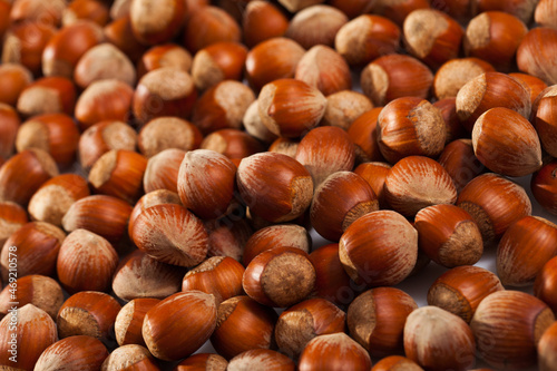 Natural background of unshelled raw hazelnuts. Healthy and nutritious snack..