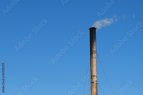 A sooty, soot-covered pipe of a coal boiler house.