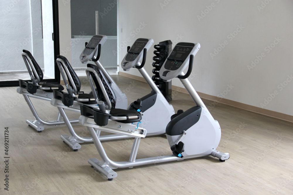 Black and white electric stationary recumbent bike in a gym for cardio, toning legs, burning calories and losing weight
