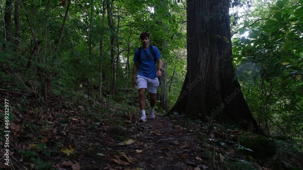 Pan-up shot of a man walking on a trail next to Maremeck River in Missouri. Pan-up shot of a man walking on a trail next to Maremeck River in Missouri.