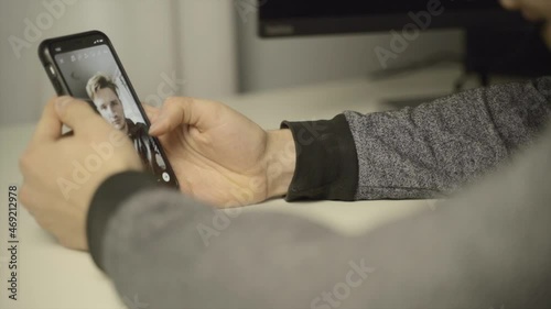 Close up of a man scrolling through selfie filters on his phone camera app photo