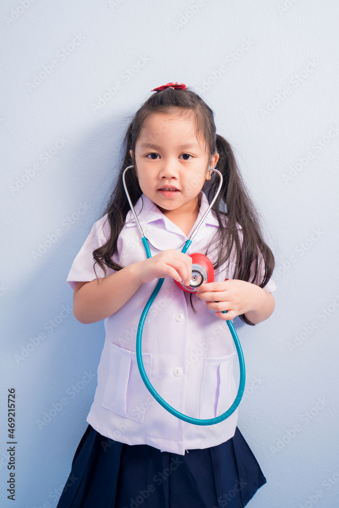 Happy cute girls in white medical uniform and stethoscope act like doctor. child dreams of becoming a doctor career concept