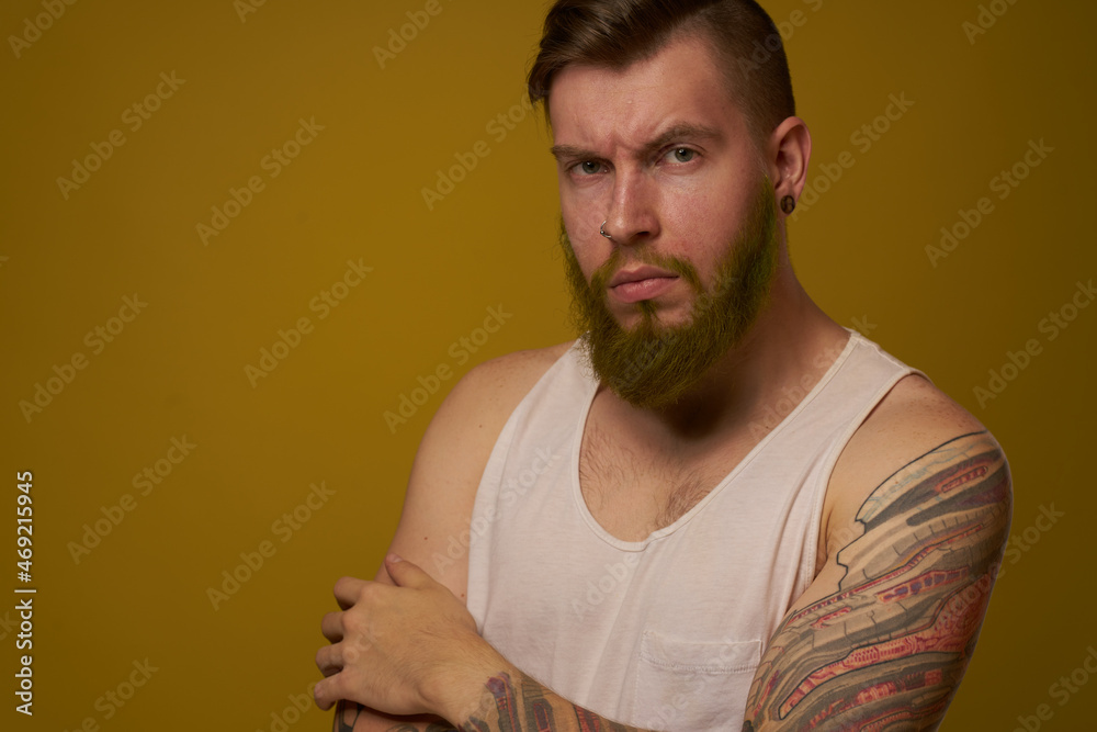 bearded man in white t-shirt with tattoos on his arms posing serious look bearded man in white t-shirt with tattoos on his arms posing serious look