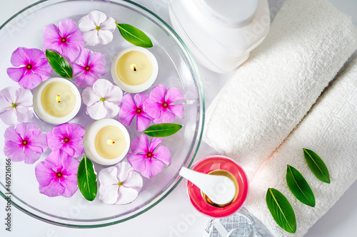 Face and body care products with pink flowers. Freshness and body care. Skin cosmetics. White clear towels for purity