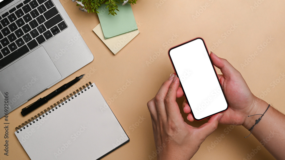 Obraz premium Overhead view young man holding smart phone with empty display.