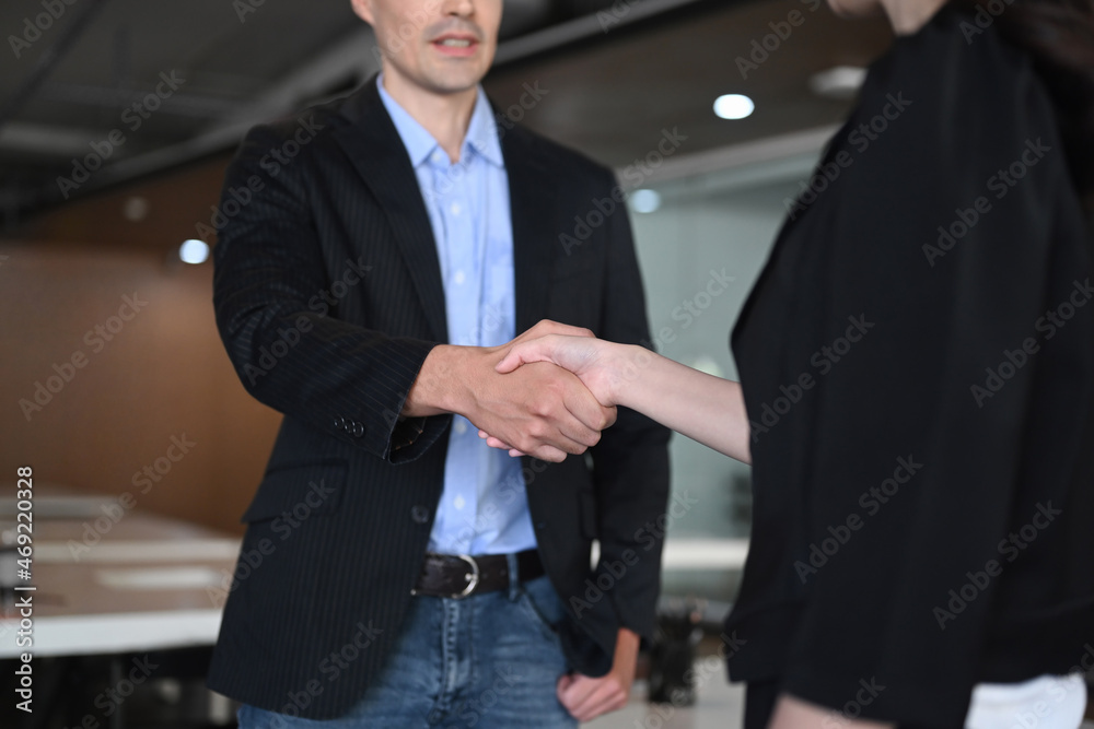 Businesspeople shaking hands after finishing up meeting or negotiation in office.