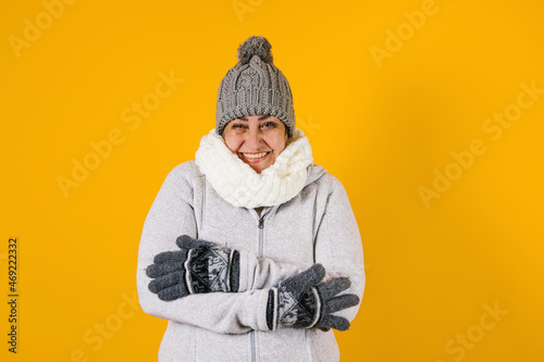 Portrait of Latin senior woman smiling and pointing up on a yellow background in Mexico latin america
