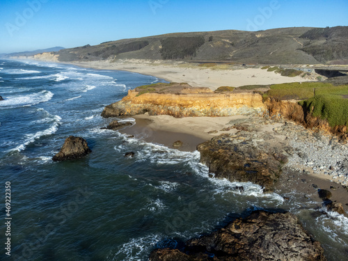 Drone view of Pescadero beach with turquoise water and blue sky.