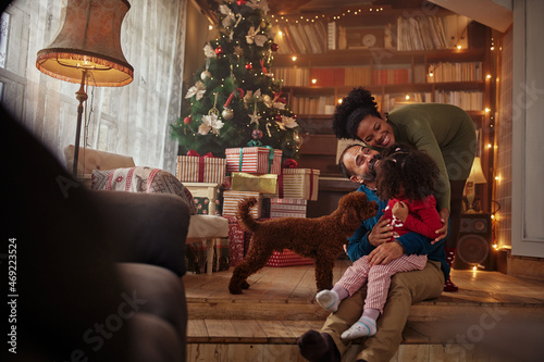 Mixed race family hugging while spending Christmas at home