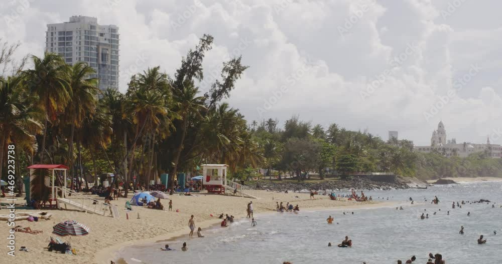 Persons relaxing lying around on the shore at Balneario del Escambron, San Juan, Puerto Rico