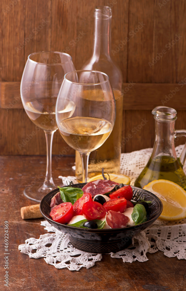 white wineand tomatoes with basil. Wine and tomatoes with basil in vintage setting on wooden table