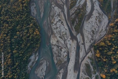 Aerial view of Laba river valley at dawn in autumn, Mostovskoy, Krasnodar Krai, Russia. Picturesque landscape, nature of Caucasus from drone. River flood, orange trees, stony coast snowy shore. photo