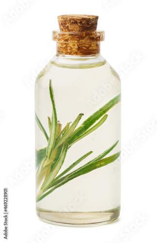 Essential oil in a small bottle with green leaf on white background