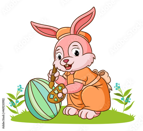 The cute rabbit is coloring the ester egg