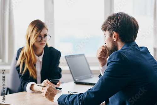 business man and woman in the office in front of a laptop career network officials
