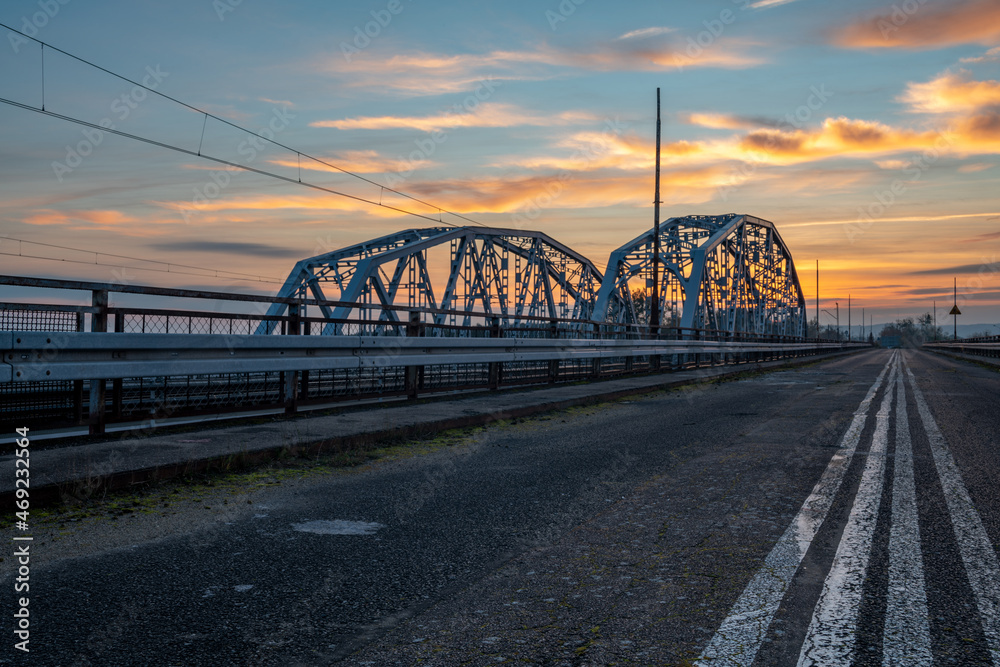 Asphalt road leading a bridge during the beautiful sunrise