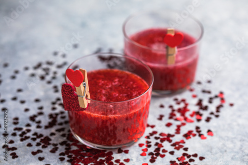 Fresh strawberry margarita or daiquiri cocktail with hearts over gray background, valentine day concepts