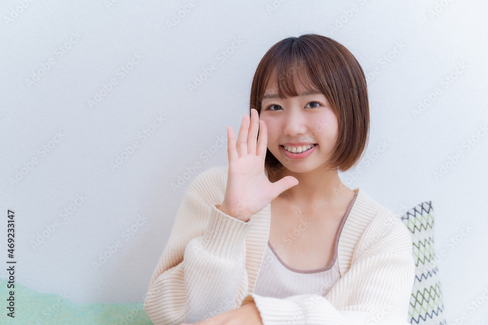 右手を口に当て呼びかける女性 右手を口に当て呼びかける女性
