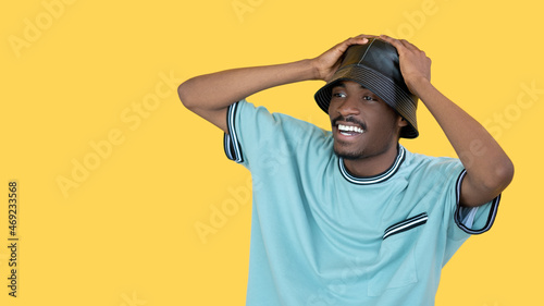 Shocked man. Rapper trend style. Unexpected news. Happy guy in sportive cloth grasping head isolated yellow looking copy space.