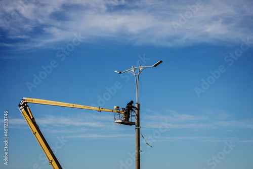 worker repair street lamp at height