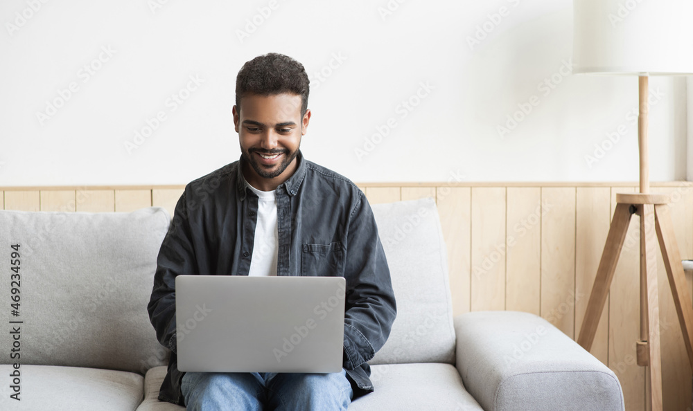 Young man using laptop computer at home. Student men working or learning online in his room. Home work or study, freelance, modern lifestyle concept Young man using laptop computer at home. Student men working or learning online in his room. Home work or study, freelance, modern lifestyle concept