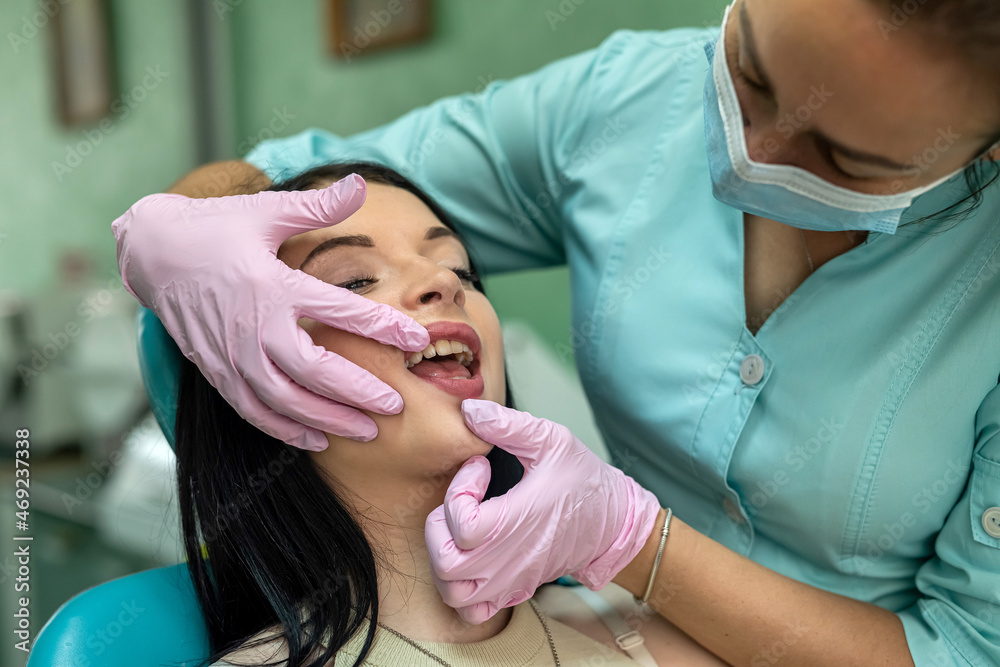 female dentist hands examines the patient's mouth female dentist hands examines the patient's mouth