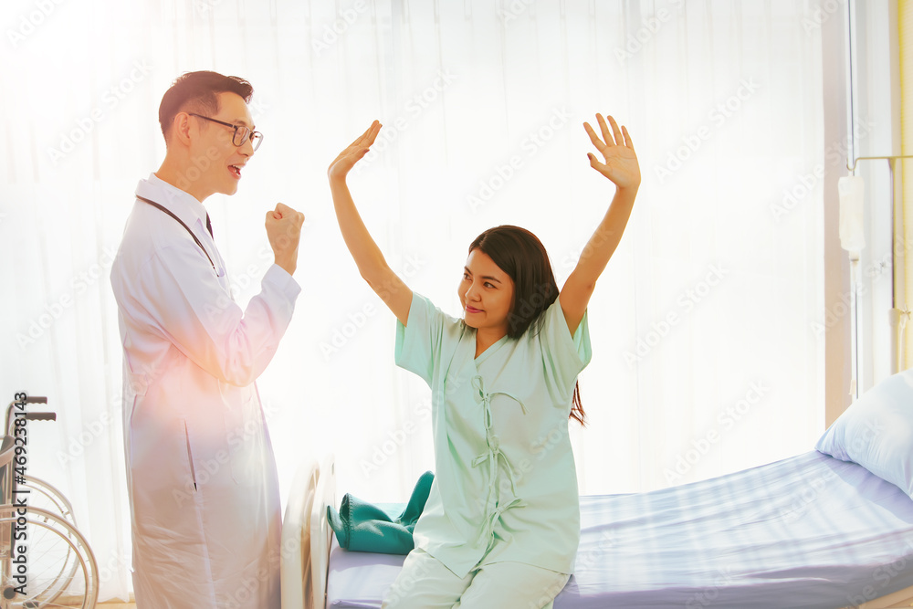 Obraz premium Doctor raised his fist very joyfully to the returning female patient in the recovery room : Happiness and encouragement of patients received from the cured doctor concept