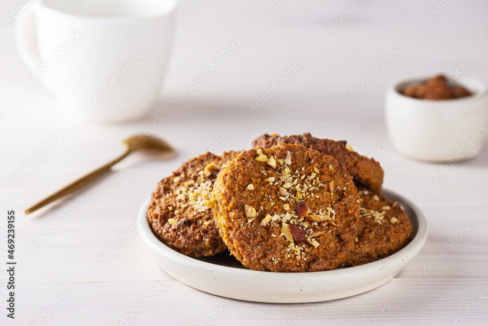 Homemade cookies with oatmeal, quinoa, carrots and nuts in a plate on a wooden table. Sugar, gluten and lactose free, vegan.