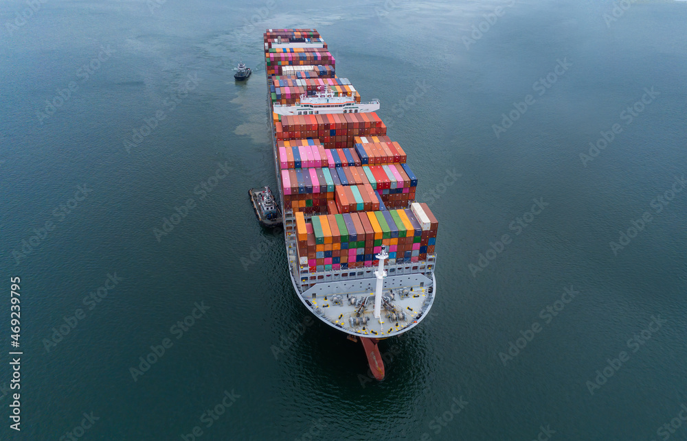 Arial view by drone camera transportation logistics and container dock cargo yard with working crane bridge in shipyard with transport logistic import export with blue sky background.