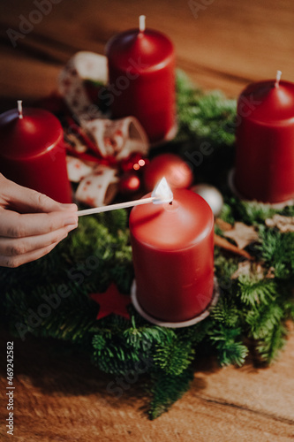 Lighting the first candle of Advent Wreath on the first Advent Sunday counting four weeks till Christmas. Old swiss tradition in December to celebrate Advent time.