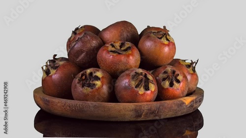 Whole ripe of organic Common Medlar rotate on white Background