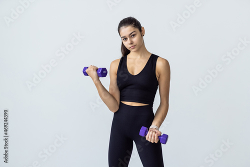 Sporty beautiful young woman exercising at home to stay fit