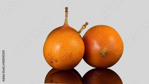 Whole ripe of organic orange Granadilla rotate on white Background.