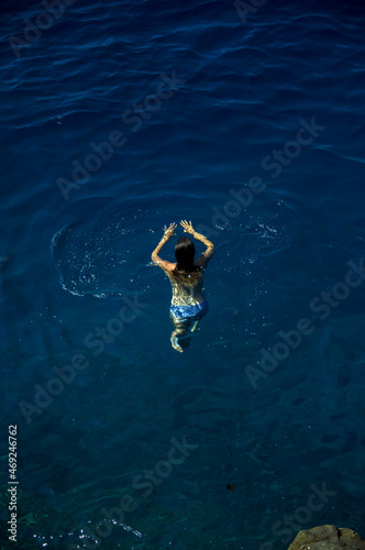 Laguna młoda kobieta z długimi włosami utrzymuje się na powierzchni  lazurowej wody