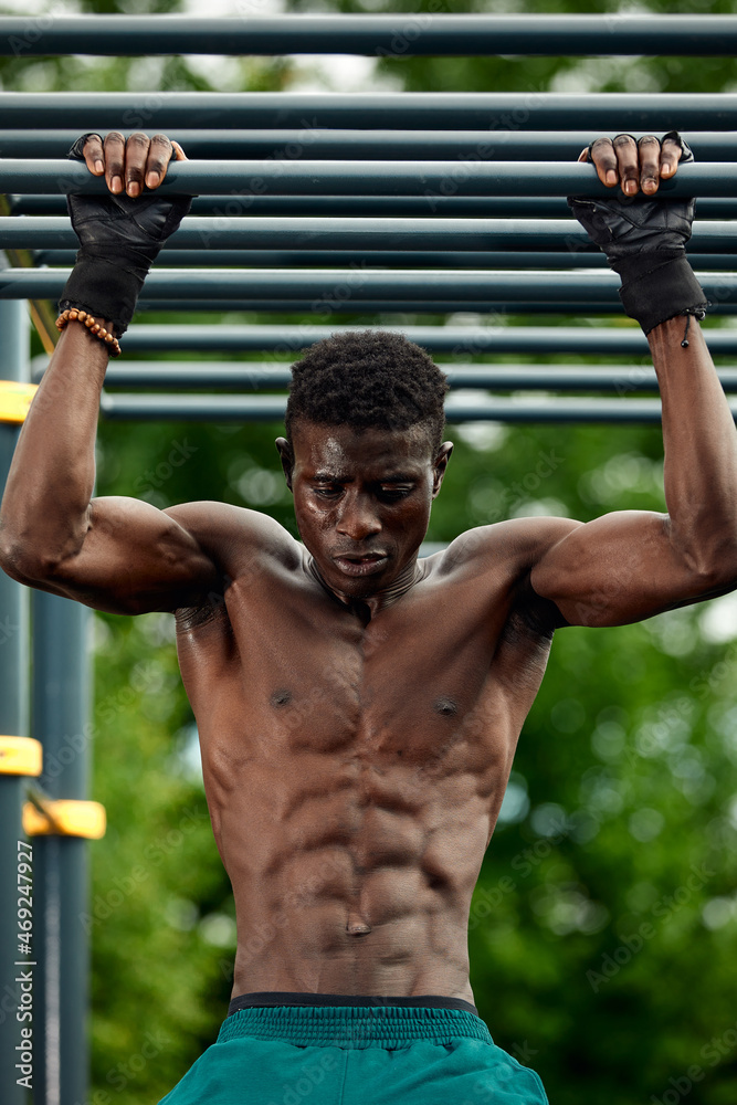 Portrait of black male working out outdoors in a park. He is using a chest machine. Portrait of black male working out outdoors in a park. He is using a chest machine.