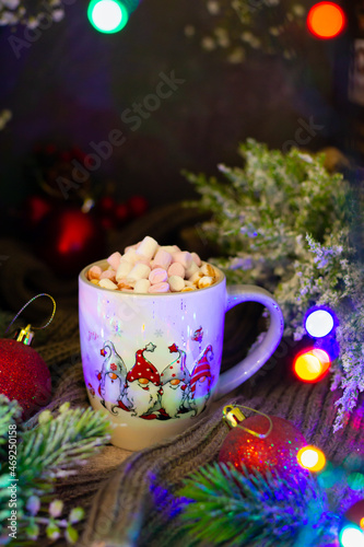 Cozy festive atmosphere highlighted by a beautifully designed mug, rich in holiday colors, surrounded by shimmering lights and the natural beauty of winter foliage.