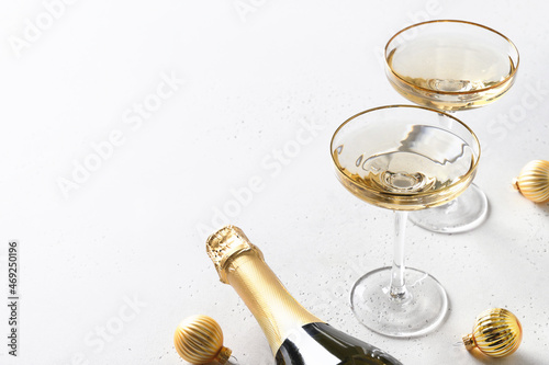 Photography Festive New Year champagne and Christmas gold baubles on white background with copy space