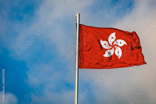 A Flag of Hong Kong an flying on a Flagpole against the Sky