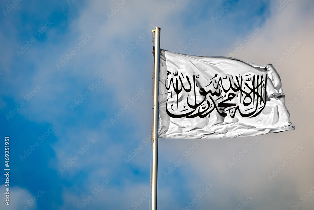 A Flag of the Taliban in Afghanistan flying on a Flagpole against the Sky