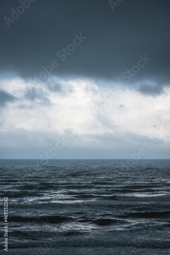 Dramatic dark blue seascape with silver shining waves during storm