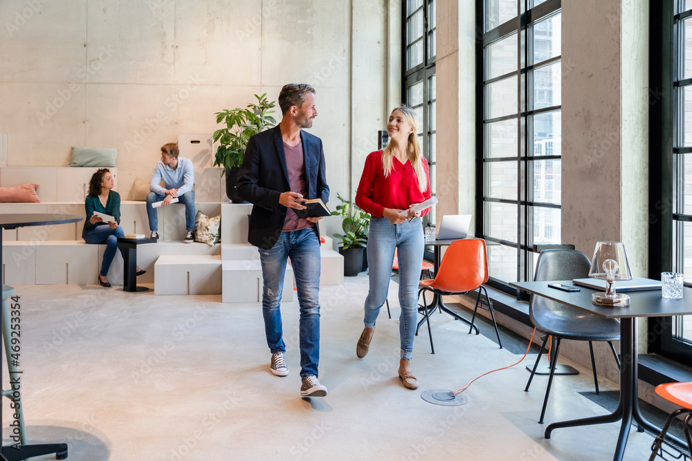 Coworkers having discussion at workplace Coworkers having discussion at workplace