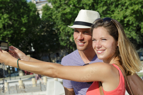 stylish young couple doing selfie outdoors