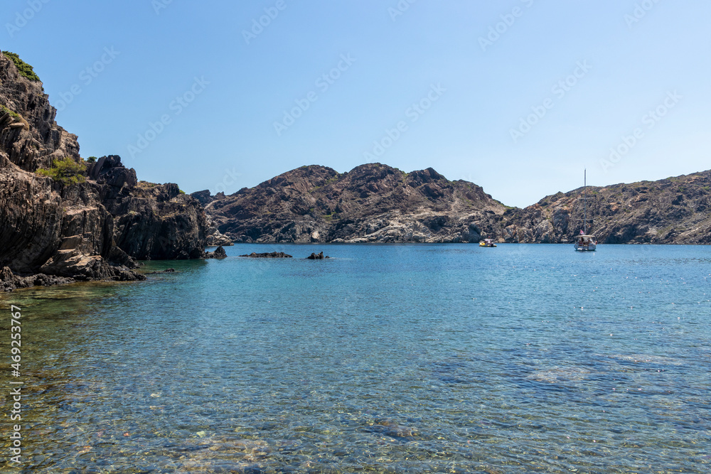boats sailing in a small bay of cap de creus on a sunny summer day