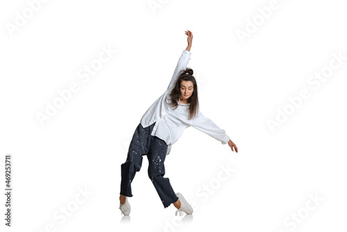 One beautiful emotive girl in casual wear moves dynamically isolated on white background. Art, motion, action, flexibility, inspiration concept.